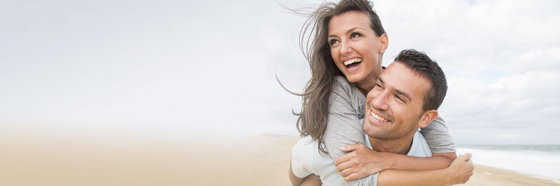 young couple smiling on beach l best dentist in columbus oh