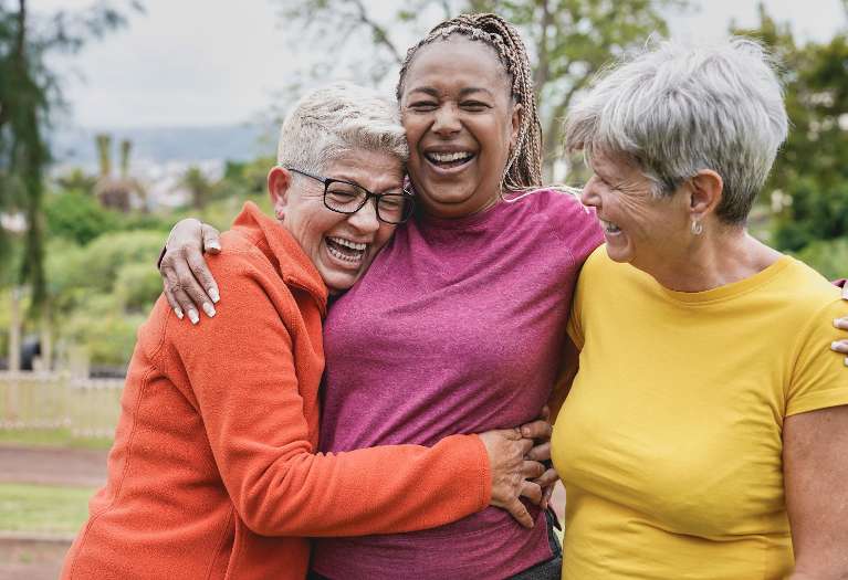 Group of women laughing confidently with their dentures in Columbus OH
