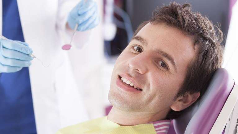 Man smiling in dental chair with brown hair, clintonville ohio