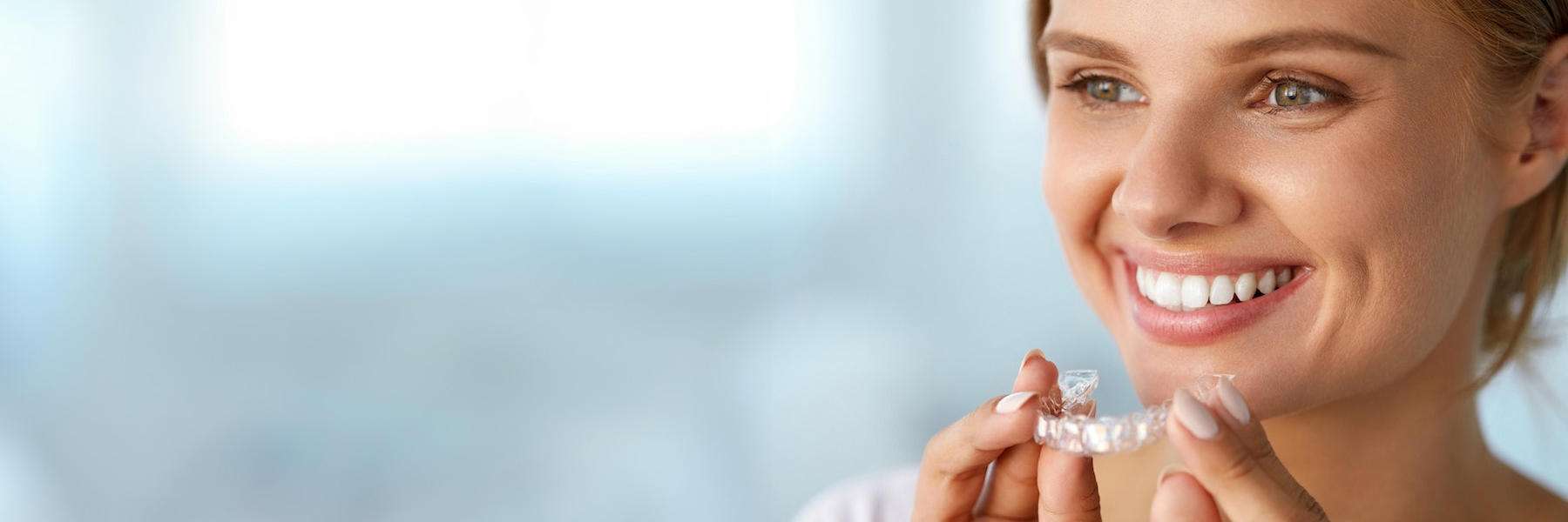 woman putting clear plastic aligner l Clear Aligners columbus oh